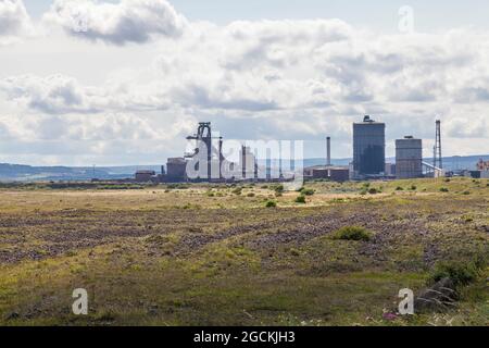 L'ex SSI altoforno visto da South Gare a Redcar, Inghilterra, Regno Unito con erba in primo piano Foto Stock