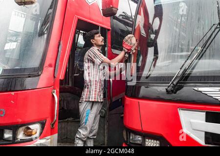 Dhaka, Bangladesh. 8 agosto 2021. Un operaio pulisce un autobus al terminal degli autobus di Gabboli. I servizi di trasporto pubblico su terra, ferrovia e corsi d'acqua sono destinati a riprendere le attività dopo la chiusura del blocco Covid-19 in corso. La Divisione gabinetto di domenica ha emesso una circolare che conferma che il blocco rigoroso a livello nazionale non verrà prorogato oltre la scadenza attuale, il 10 agosto. (Foto di Sazzad Hossain/SOPA Images/Sipa USA) Credit: Sipa USA/Alamy Live News Foto Stock