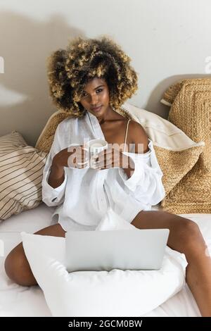 Mano di donna anonima che tiene il clam di rasoio delizioso mentre mangia nel ristorante Foto Stock