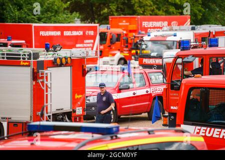 09 agosto 2021, Baviera, Hösbach: I veicoli di emergenza sono parcheggiati al punto di assemblaggio. Per combattere i gravi incendi boschivi in Grecia, l'Assia sta inviando circa 160 forze di protezione civile Assiane, tra cui vigili del fuoco e assistenti dell'Agenzia federale tedesca per il soccorso tecnico (THW), ad Atene e nella regione greca di Attica. La Grecia aveva presentato una richiesta di assistenza nell'ambito del meccanismo di protezione civile dell'UE. Foto: Andreas Arnold/dpa Foto Stock