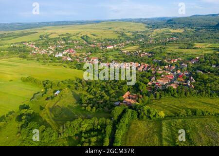 Sorvolando un villaggio in Transilvania. Drone aereo vista di Manastireni, Romania con drone Foto Stock