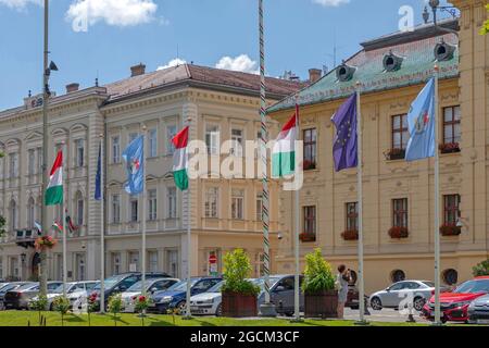 Szeged, Ungheria - 16 giugno 2021: Bandiera ungherese e dell'Unione europea di fronte al municipio di Szeged, Ungheria. Foto Stock