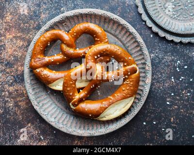 i pretzel salati nel cuore si formano su uno sfondo blu scuro Foto Stock