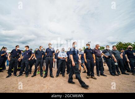 09 agosto 2021, Baviera, Hösbach: Le forze di emergenza si trovano al punto di riunione mentre partono per la Grecia. Per combattere i gravi incendi boschivi in Grecia, l'Assia sta inviando circa 160 forze di protezione civile Assiane, tra cui vigili del fuoco e assistenti dell'Agenzia federale tedesca per il soccorso tecnico (THW), ad Atene e nella regione greca di Attica. La Grecia aveva presentato una richiesta di assistenza nell'ambito del meccanismo di protezione civile dell'UE. Foto: Andreas Arnold/dpa Foto Stock