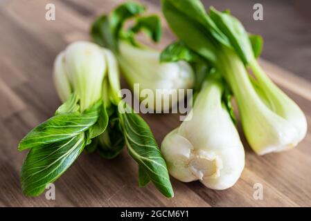 Vista ad alto angolo del fresco Bok Choy, cavolo cinese, su tagliere di legno Foto Stock