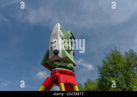 Macchina per topografi con cielo blu e alberi verdi in giorno di sole Foto Stock