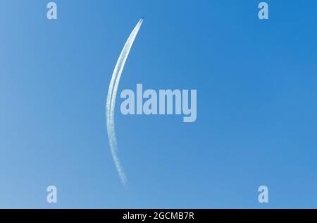 Gli aeroplani che lasciano la traccia controtaia si trasformano in un cielo blu chiaro Foto Stock