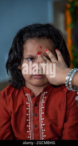 Famiglie indiane che celebrano il festival di Raksha Bandhan un festival per celebrare il legame tra fratello e sorella. Rakhi celebrazione in India. Alimentazione dei dolci, applicazione di tikka. Foto Stock