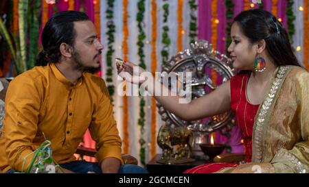 Famiglie indiane che celebrano il festival di Raksha Bandhan un festival per celebrare il legame tra fratello e sorella. Rakhi celebrazione in India. Alimentazione dei dolci, applicazione di tikka. Foto Stock