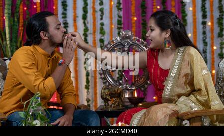 Famiglie indiane che celebrano il festival di Raksha Bandhan un festival per celebrare il legame tra fratello e sorella. Rakhi celebrazione in India. Alimentazione dei dolci, applicazione di tikka. Foto Stock