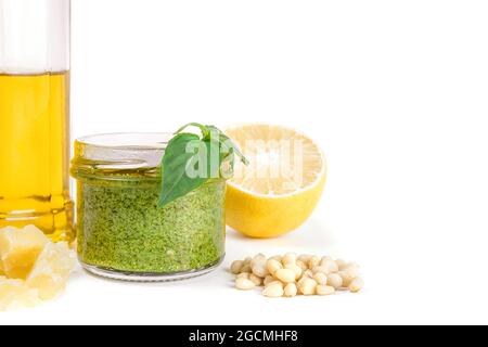 Ricetta ingredienti pesto di salsa italiana. Salsa di pesto verde fatta in casa con basilico, pinoli, aglio, limone, olio d'oliva su fondo bianco chiaro Foto Stock