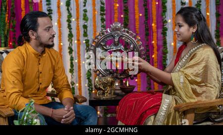 Famiglie indiane che celebrano il festival di Raksha Bandhan un festival per celebrare il legame tra fratello e sorella. Rakhi celebrazione in India. Alimentazione dei dolci, applicazione di tikka. Foto Stock