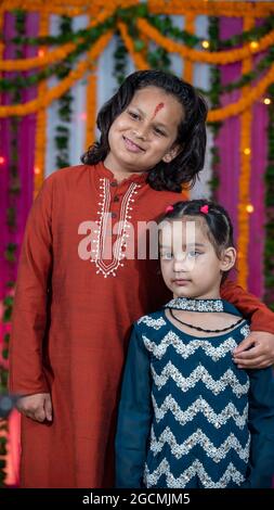 I bambini indiani indossano abiti etnici indiani durante Raksha Bandhan, un festival per celebrare il legame tra la sorella. Decorazione in case indiane. Foto Stock