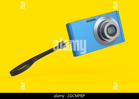 Elegante fotocamera digitale tascabile compatta blu isolata su sfondo giallo. Concetto di destinazione di viaggio in vacanza con rendering 3D Foto Stock