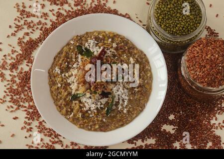 Porridge o gruel a base di riso Navara, fagioli mungs e semi di fieno cosparsi di cocco fresco grattugiato. Conosciuto anche come navara kichadi o uluva kanji Foto Stock