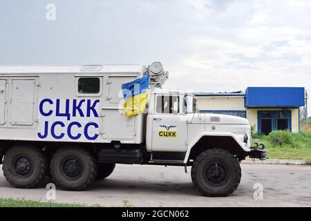 Krasnogorivka, Ucraina. 8 agosto 2021. Il camion JCCC (Joint Control and Coordination Commission) è visto sulla strada nel sobborgo di Krasnogorivka. Un condominio residenziale a Krasnogorivka, è stato abbattuto la mattina del 5 agosto. Un civile è stato gravemente ferito nel suo appartamento. Il conflitto armato nell'Ucraina orientale continua a pagare un tributo elevato ai civili, dalla minaccia alla loro sicurezza fisica alla limitazione dell'accesso a cibo, medicinali, alloggi adeguati e scuole. Credit: SOPA Images Limited/Alamy Live News Foto Stock