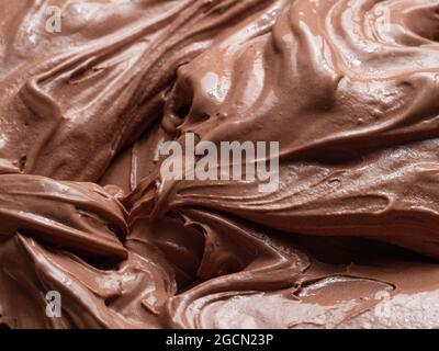 Gelato al gusto di cioccolato - dettaglio a cornice. Primo piano di una superficie marrone di gelato al cioccolato. Foto Stock