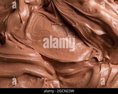 Gelato al gusto di cioccolato - dettaglio a cornice. Primo piano di una superficie marrone di gelato al cioccolato. Foto Stock