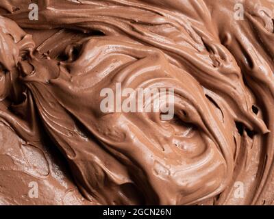 Gelato al gusto di cioccolato - dettaglio a cornice. Primo piano di una superficie marrone di gelato al cioccolato. Foto Stock