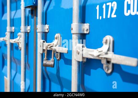 Primo piano del contenitore. Contenitore di carico blu con serratura. Il concetto di aumento dei costi di trasporto. Banner con posizione per il testo. Foto Stock