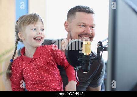 Ridendo la ragazza e l'uomo cantano la canzone nel closeup del microfono Foto Stock