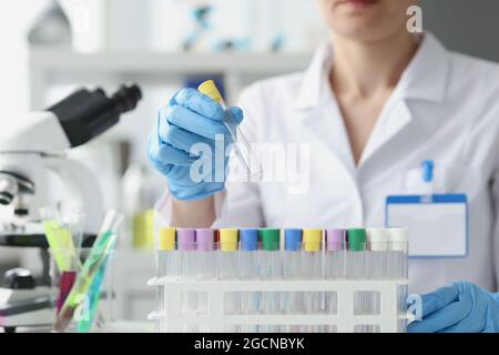 Lo scienziato tiene la provetta vuota in guanti in laboratorio Foto Stock