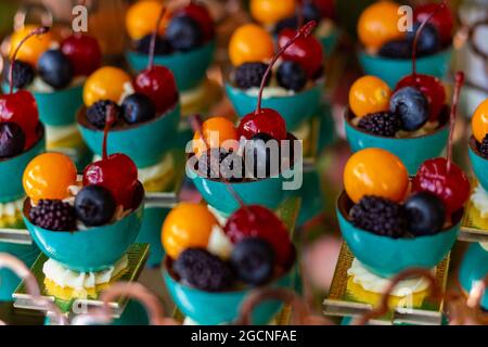 Quattro frutti diversi, disposti in ciotole su un tavolo a buffet decorato per una festa. Foto Stock