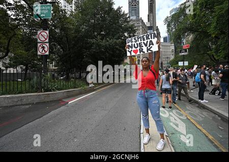 Una donna ha un cartello "Wake Up New York" (in spagnolo) sulla rampa del ponte di Brooklyn mentre si unisce ai manifestanti che tengono un rally fuori dal municipio contro le vaccinazioni COVID-19 e mandati per le persone a vaccinarsi, New York, NY, 9 agosto 2021. New York sarà la prima città a vietare le persone non vaccinate da ristoranti, palestre e locali di intrattenimento al coperto a partire dal 16 agosto, con attuazione a partire dal 13 settembre; la variante Delta del Coronavirus ha causato un aumento delle infezioni COVID-19 in tutti gli Stati Uniti, soprattutto tra i non vaccinati. (Anthony Behar/Sipa USA) Foto Stock