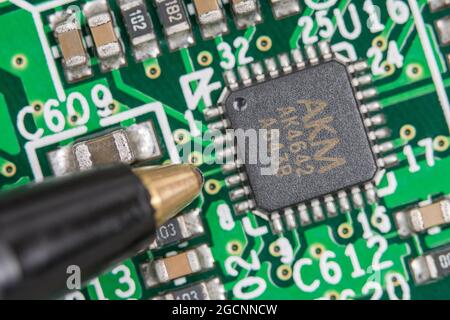Chip IC AKM a 32 pin su circuito stampato/scheda a circuito stampato legacy. Creduto essere un chip codec audio. Mettere a fuoco la metà sinistra del chip. Scala dalla punta della penna a sfera Foto Stock