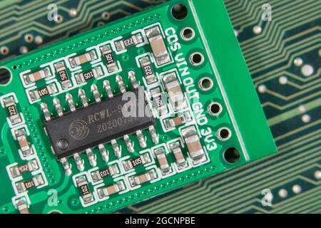 Chip IC macro close-up su circuito stampato con sensore di movimento di piccole dimensioni. Informazioni sulla scritta RCWL-0516. Il chip è un chip di controllo per l'elaborazione del segnale di trasmissione. Foto Stock