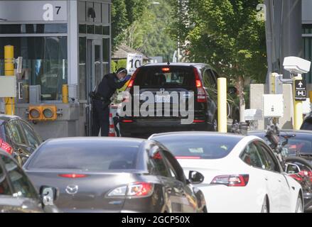 Surrey, Canada. 9 agosto 2021. Un ufficiale di frontiera canadese ispeziona un veicolo dagli Stati Uniti al valico di frontiera dell'arco della Pace a Surrey, British Columbia, Canada, il 9 agosto 2021. Il Canada ha iniziato unilateralmente a consentire l'ingresso da parte di cittadini statunitensi e residenti permanenti completamente vaccinati lunedì dopo che i due paesi hanno accettato di chiudere il confine a viaggi non essenziali a causa della pandemia COVID-19 17 mesi fa. Credit: Liang Sen/Xinhua/Alamy Live News Foto Stock