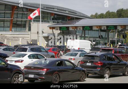 Surrey, Canada. 9 agosto 2021. I veicoli si allineano per entrare in Canada all'attraversamento del confine dell'arco della Pace a Surrey, British Columbia, Canada, il 9 agosto 2021. Il Canada ha iniziato unilateralmente a consentire l'ingresso da parte di cittadini statunitensi e residenti permanenti completamente vaccinati lunedì dopo che i due paesi hanno accettato di chiudere il confine a viaggi non essenziali a causa della pandemia COVID-19 17 mesi fa. Credit: Liang Sen/Xinhua/Alamy Live News Foto Stock