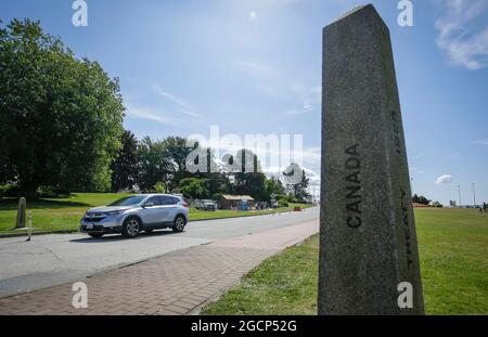 Surrey, Canada. 9 agosto 2021. Un veicolo dagli Stati Uniti passa attraverso un marcatore di confine al confine dell'arco della Pace a Surrey, British Columbia, Canada, il 9 agosto 2021. Il Canada ha iniziato unilateralmente a consentire l'ingresso da parte di cittadini statunitensi e residenti permanenti completamente vaccinati lunedì dopo che i due paesi hanno accettato di chiudere il confine a viaggi non essenziali a causa della pandemia COVID-19 17 mesi fa. Credit: Liang Sen/Xinhua/Alamy Live News Foto Stock