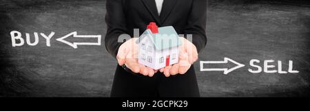 Broker immobiliare mostrando casa in miniatura per acquistare e vendere casa di mercato concetto. Banner panoramico su nero lavagna donna che tiene a casa con Foto Stock