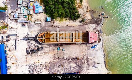 Old fisher barca nel cantiere a Johor Bahru, Malesia. Una barca di legno fuori dal mare per la riparazione. Una vista aerea su una barca pescatore malese. Dro Foto Stock