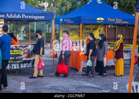 Kuala Lumpur, Malesia - 16 ottobre 2020: La gente si accatola per una bancarella di cibo di strada in un mercato di strada. Il cibo di strada è molto popolare in Malesia. A causa di Foto Stock