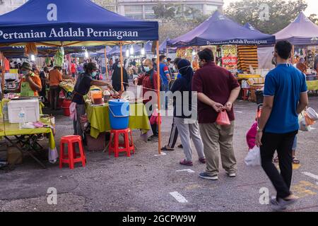 Kuala Lumpur, Malesia - 16 ottobre 2020: La gente si accatola per una bancarella di cibo di strada in un mercato di strada. Il cibo di strada è molto popolare in Malesia. A causa di Foto Stock
