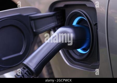 Cavo elettrico inserito nell'auto per la ricarica della stazione di ricarica Foto Stock