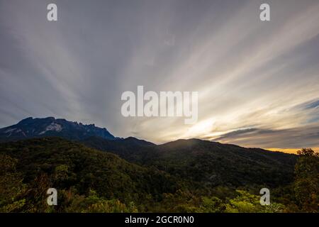 Alba al Monte Kinabalu, Borneo, Sabah, Malesia. Il sole sorge dietro la montagna più alta del sud-est asiatico, il monte kinabalu. Vicino a. Foto Stock