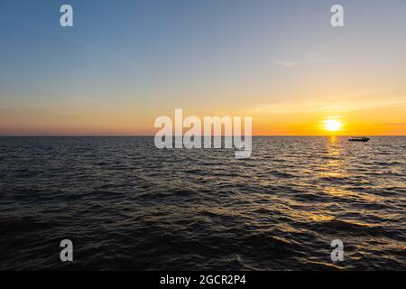 Tramonto al lago Tonle SAP, Cambogia, vicino al villaggio galleggiante Kampong Phluk e Siem Reap. Barche turistiche che navigano sull'acqua per godersi il respiro Foto Stock