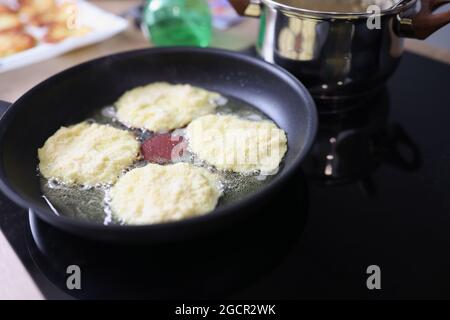 I frittelle di farina vengono fritti nel casseruola Foto Stock