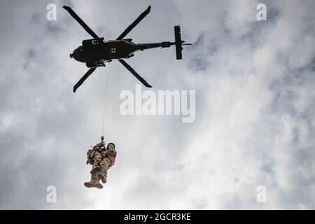 Alaska Army National Guard Soldiers assegnato al 1 ° Battaglione, 207th Aviation Regiment eseguire Medical evacuazione paranco addestramento accanto Airmen con il 39 ° Airlift Squadron basato in Texas vicino Bryant Army Airfield sulla base congiunta Elmendorf-Richardson 9 agosto 2021. I militari utilizzavano un UH-60 Blackhawk e un C-130 Hercules per simulare un'estrazione reale. (STATI UNITI Army National Guard foto di Sgt. Seth LaCount) Foto Stock