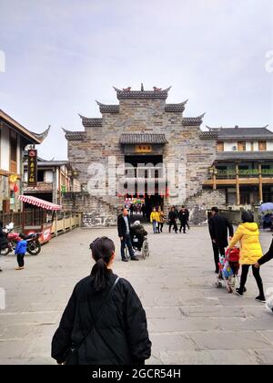 Una bella ragazza cinese in piedi prima di un antico edificio in mattoni in stile pagoda nel distretto di Nanxi di Yibin Foto Stock