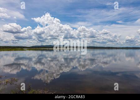 Effetto specchio d'acqua sul lago di Minneriya Wewa al Parco Nazionale di Minneriya , Sri Lanka. Paesaggio nuvoloso panorama fotografia di paesaggio con riflessione o Foto Stock