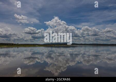 Effetto specchio d'acqua sul lago di Minneriya Wewa al Parco Nazionale di Minneriya , Sri Lanka. Paesaggio nuvoloso panorama fotografia di paesaggio con riflessione o Foto Stock