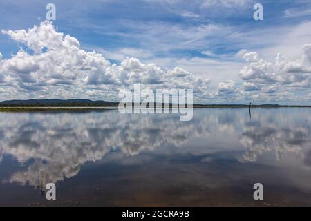 Effetto specchio d'acqua sul lago di Minneriya Wewa al Parco Nazionale di Minneriya , Sri Lanka. Paesaggio nuvoloso panorama fotografia di paesaggio con riflessione o Foto Stock