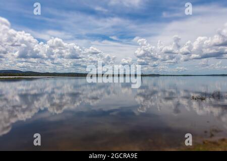 Effetto specchio d'acqua sul lago di Minneriya Wewa al Parco Nazionale di Minneriya , Sri Lanka. Paesaggio nuvoloso panorama fotografia di paesaggio con riflessione o Foto Stock