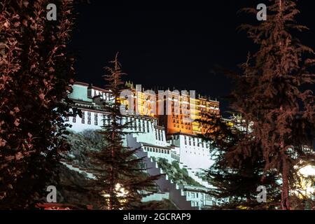 Lhasa, capitale del Tibet. Il Palazzo Potala illuminato a Lhasa, Tibet, Cina. Una lunga esposizione a Chengguan, sul lato della strada con vi Foto Stock