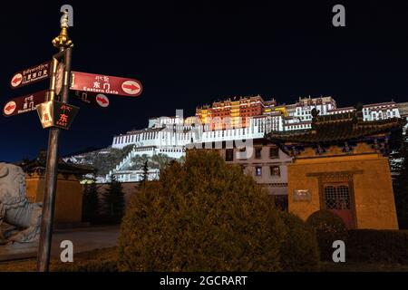 Lhasa, capitale del Tibet. Il Palazzo Potala illuminato a Lhasa, Tibet, Cina. Una lunga esposizione a Chengguan, sul lato della strada con vi Foto Stock