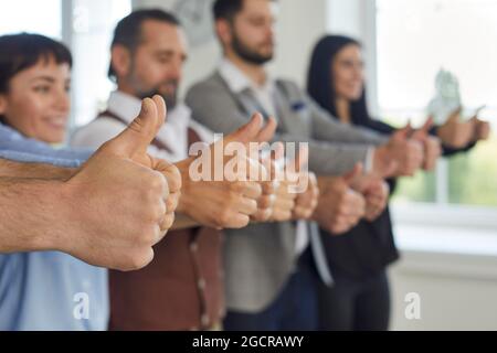 Gruppo di uomini d'affari felici che mostrano segno di successo. Foto Stock